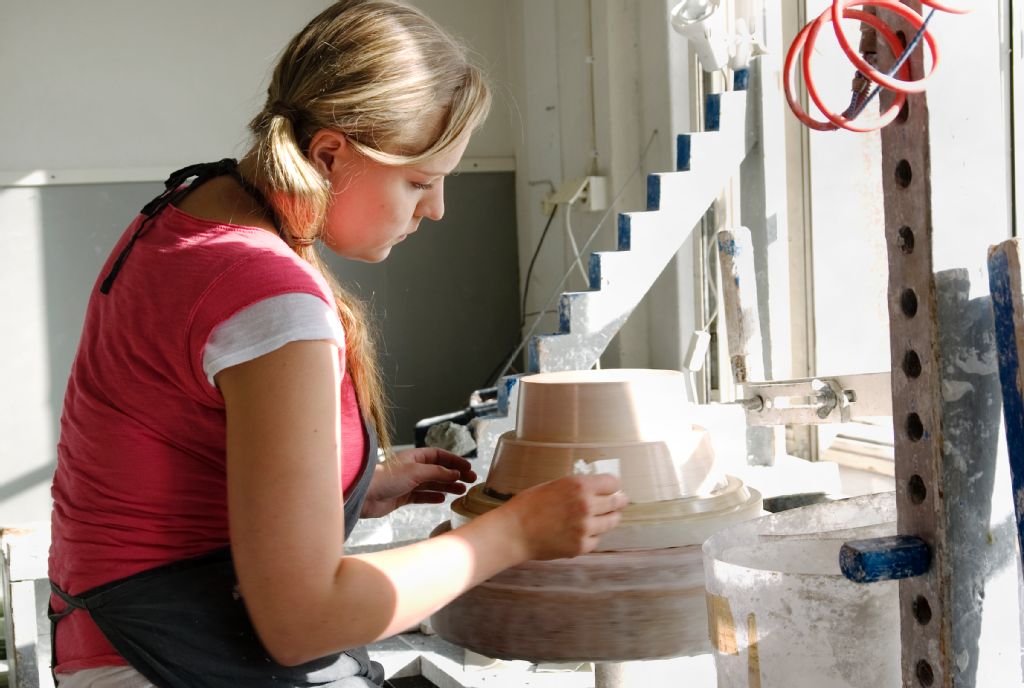 Taideteollisen korkeakoulun opiskelijoita: työskentelyä keramiikkapajalla